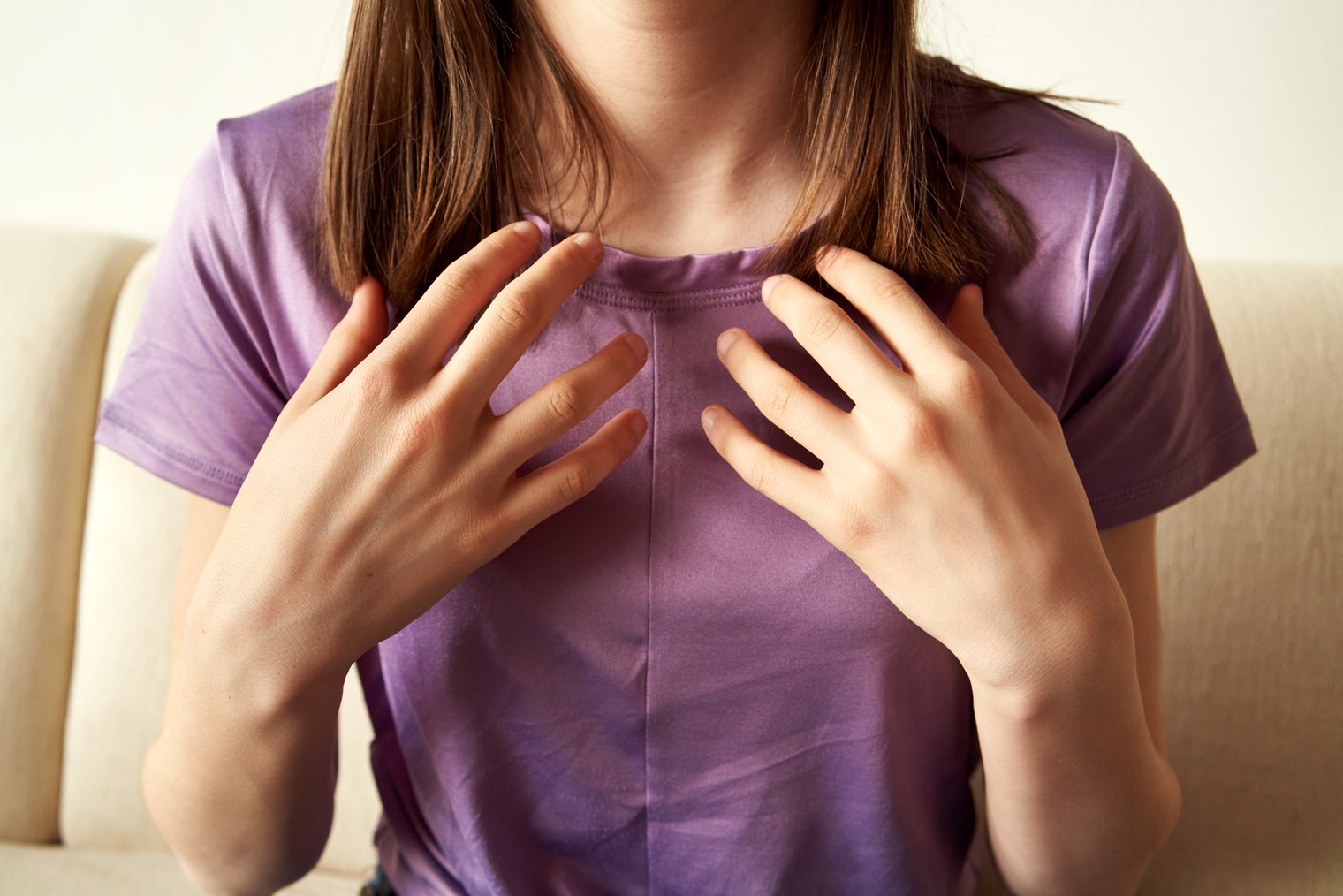 Teenager practicing EFT or emotional freedom technique - tapping on clavicle point